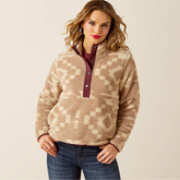 Woman wearing a patterned fleece pullover against a beige background